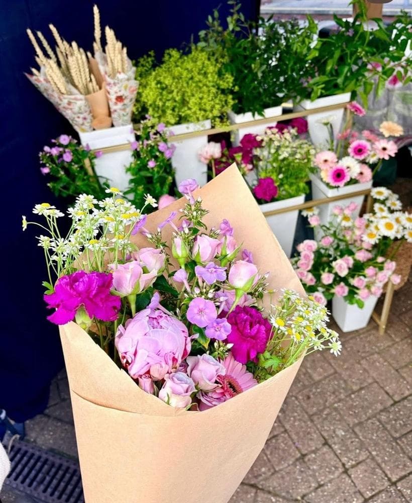 A pink bouquet in front of the flower stand
